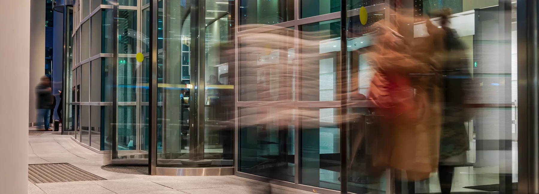 blurred people passing through a revolving door
