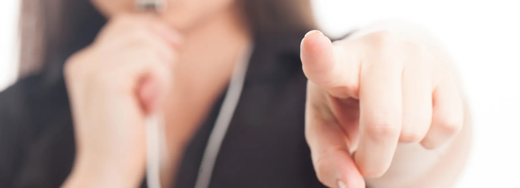 A woman pointing and blowing a whistle
