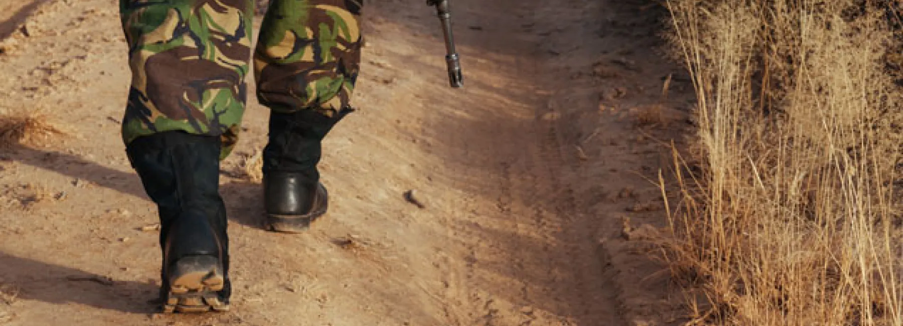 Soldier walking on a dirt road