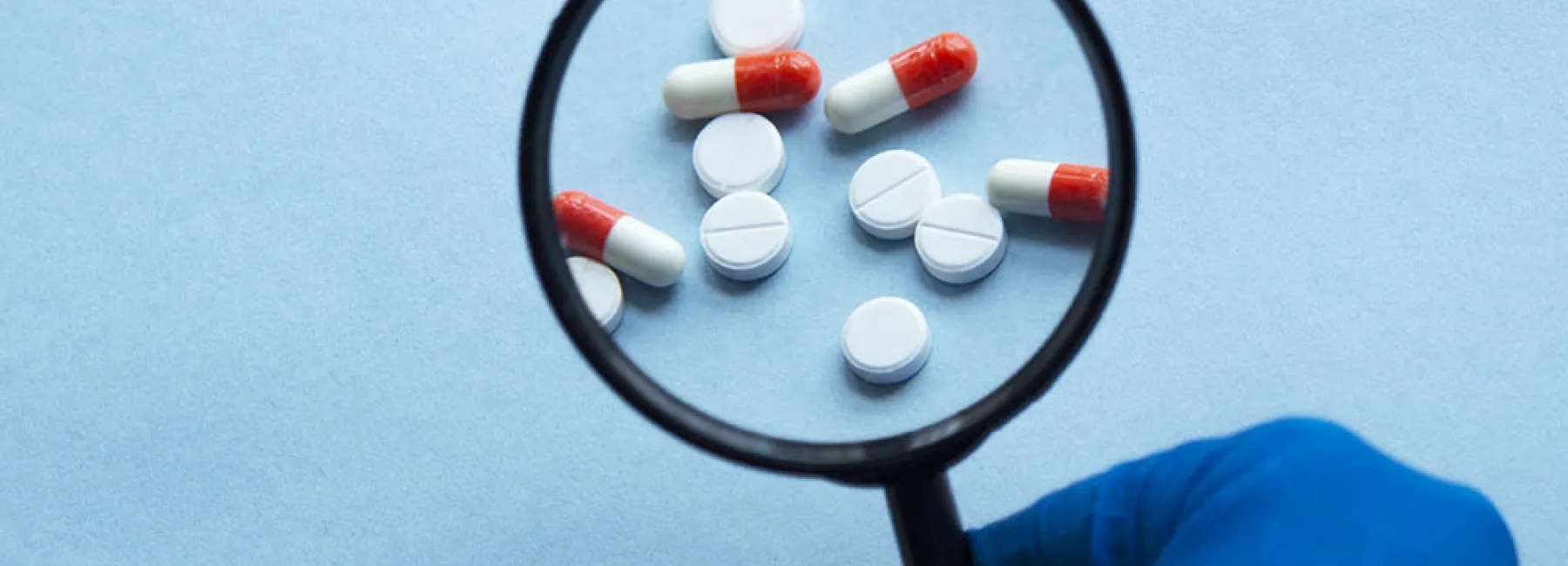 Magnifying glass and pills
