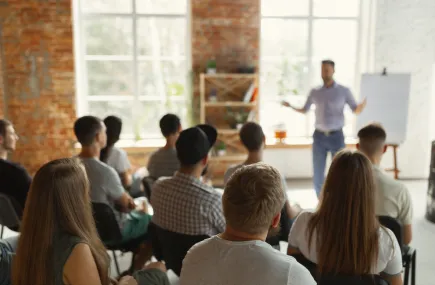 A man giving a presentation in front of a flip chart