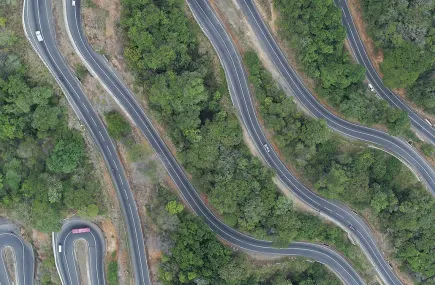 aerial view of road winding up a hill